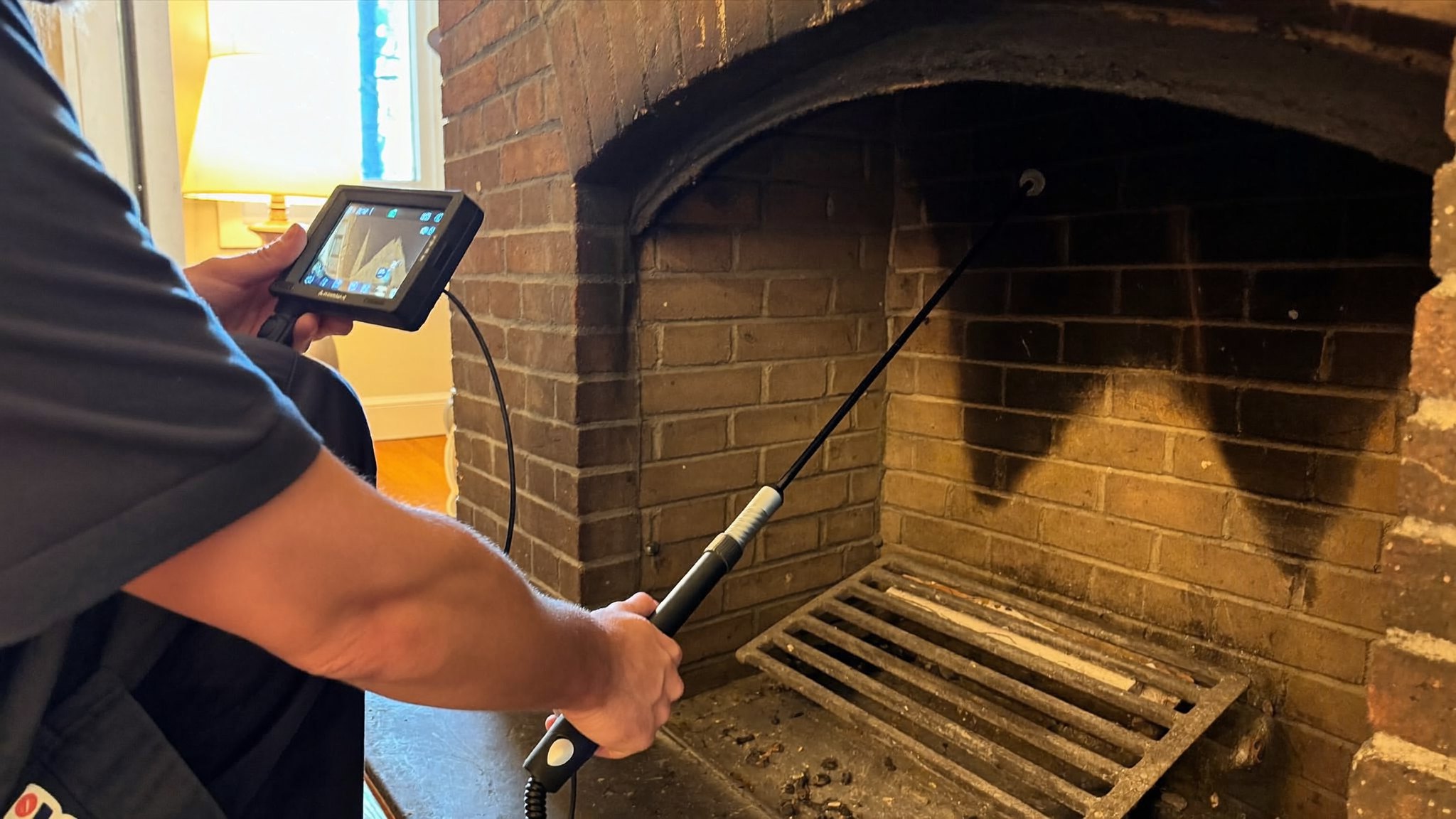 Technician running a video camera scan of a flue during a Level 2 chimney inspection in a Dallas Fort Worth home