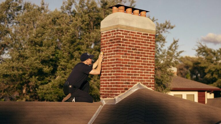 A CSIA certified ALC technician inspecting an open masonry chimney flue on a Dallas Fort Worth rooftop during chimney swift season in Texas